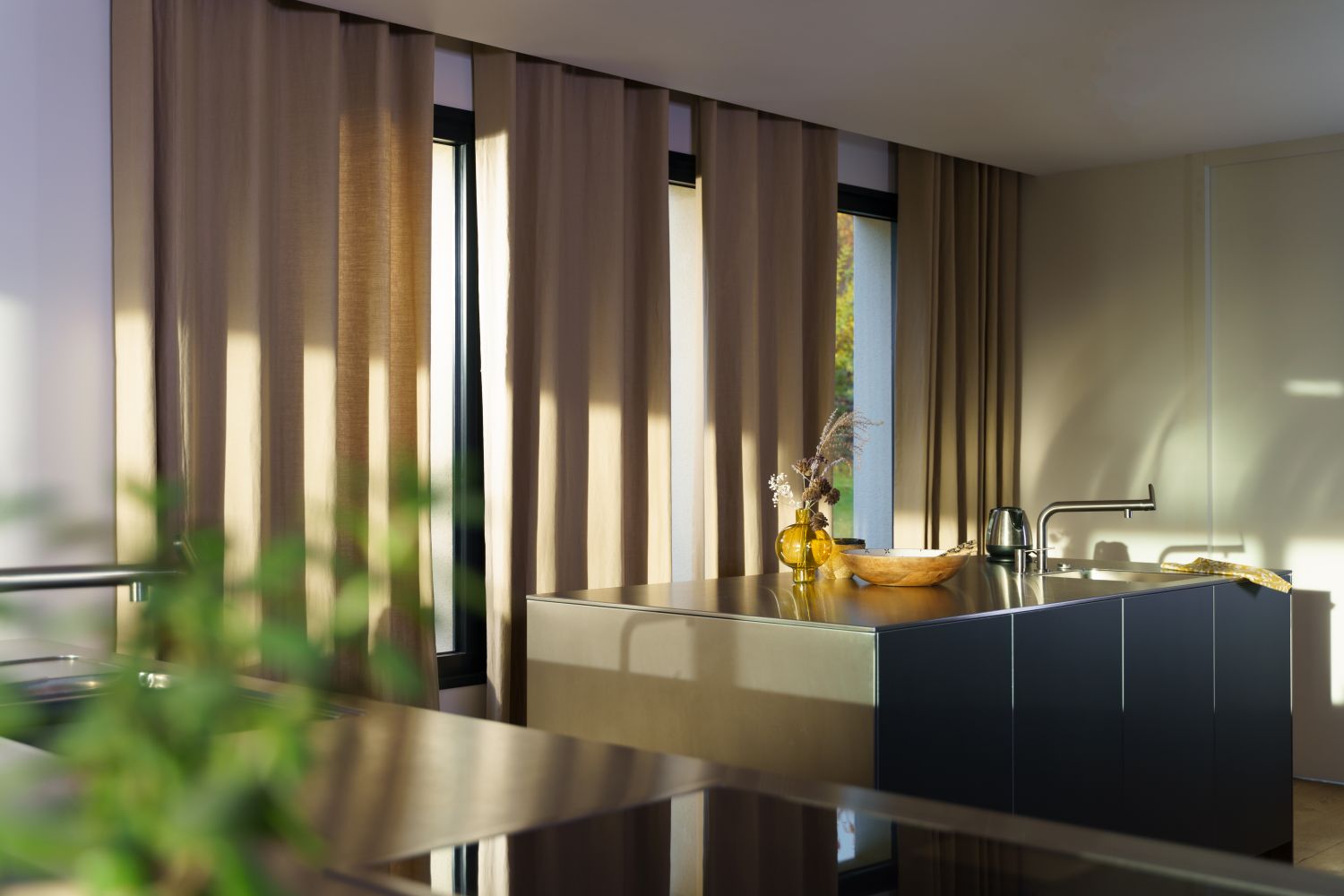 atmosfera calda lumina naturala bucatarie amenajata minimalist cu ferestre mari si jaluzele neutre