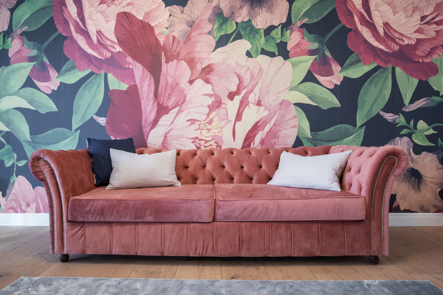 tapet pe un perete in living model floral bujori supradimensionati si canapea roz prafuit