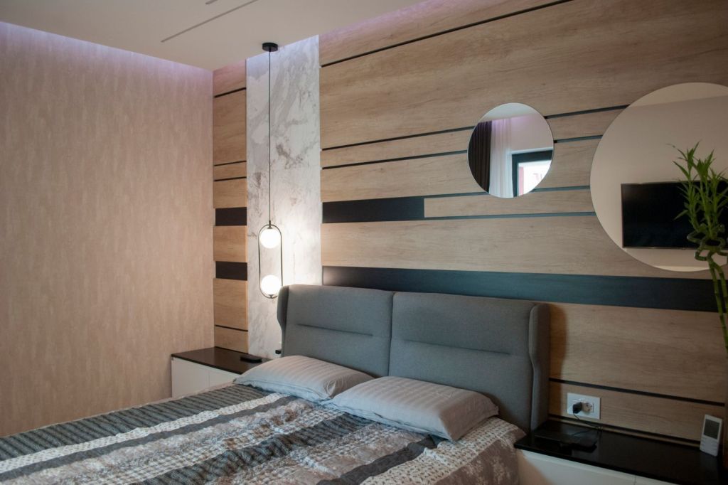 amenajare dormitor matrimonial regula 70 30 design interior cu perete placat cu lemn si marmura cu insertii negre si oglinzi pat dublu si noptiere integrate