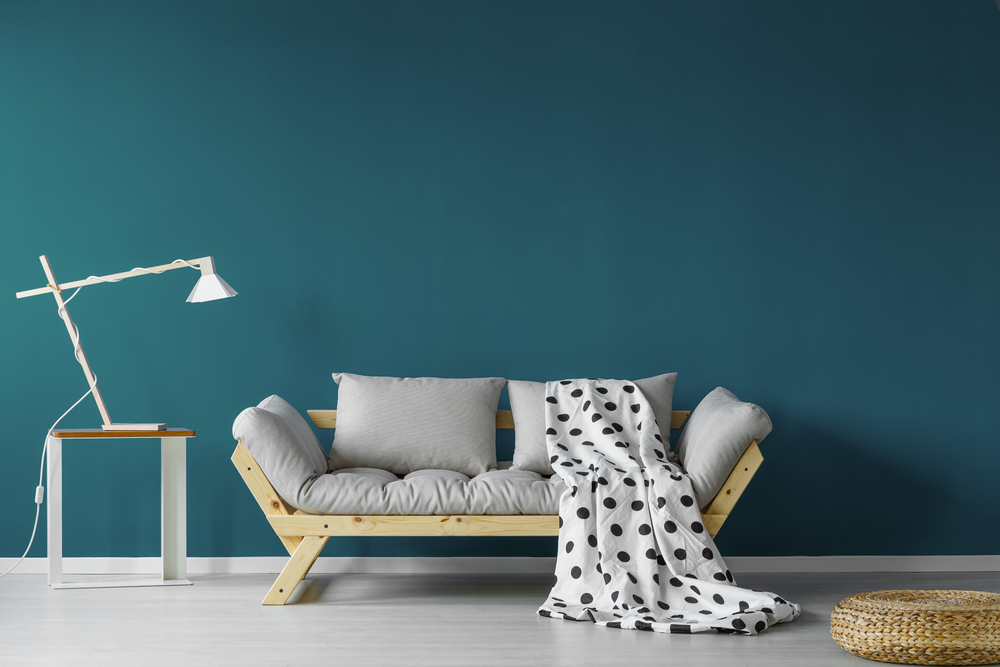 perete vopsit in designul unei camere cu canapea si lampa