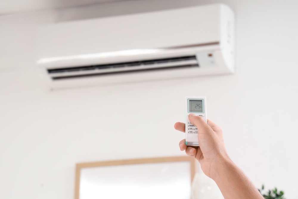 aparat aer conditionat in casa setare temperatura de catre o femeie din telecomanda