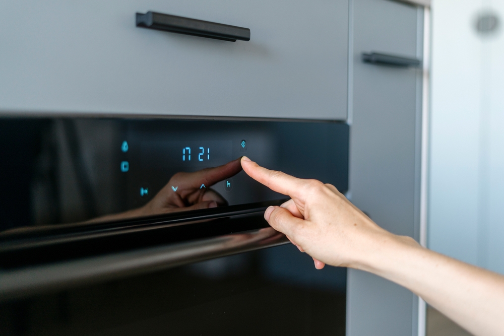 cuptor electric smart cu butoane touch atinse de mana femeie 