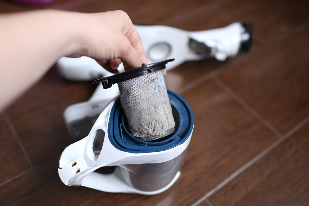 filtru murdar aspirator ținut in mana de femeie