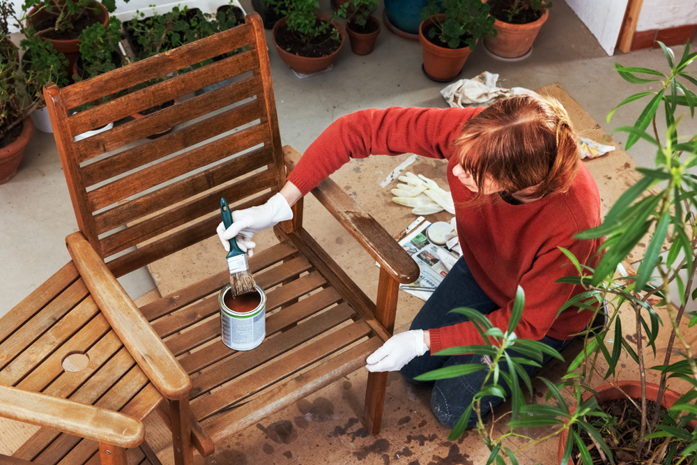 mobilier exterior dat cu ulei de către femeie înainte de venirea iernii 