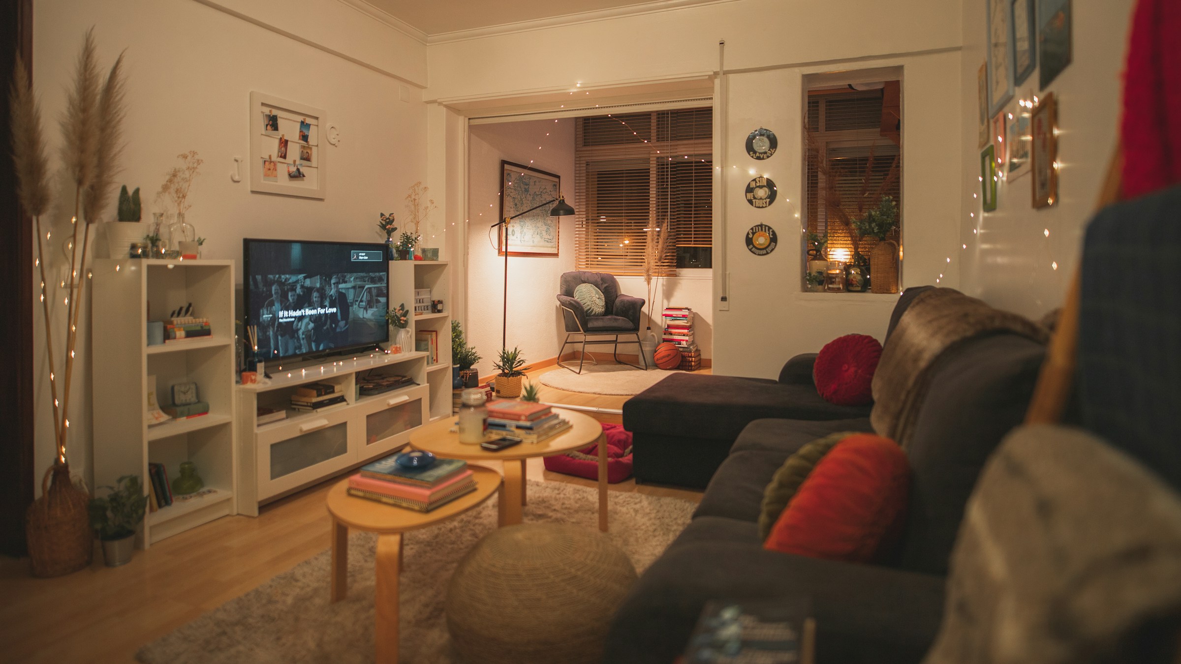 interior living cozy cu lumina ambientala canapea confortabila gri pereti albi comoda media alba televizor si colt de relaxare cu fotoliu si lampadar
